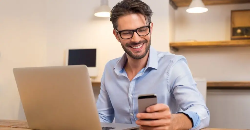 Man at desk selecting from gift card options on his phone