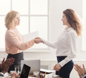 Employee and manager shaking hands showing appreciation for a job well done