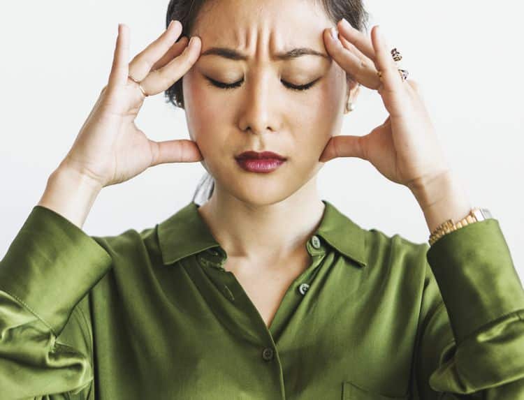 Stressed woman holding her head - National Stress Awareness Month