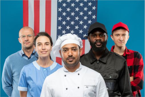 Group of veterans from all departments of a company standing in front of a flag