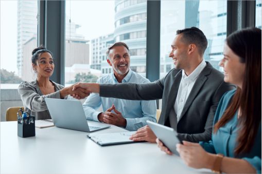 Business team around a table showing gratitude to one of the members