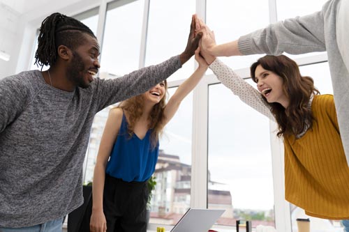 colleagues giving high five at work