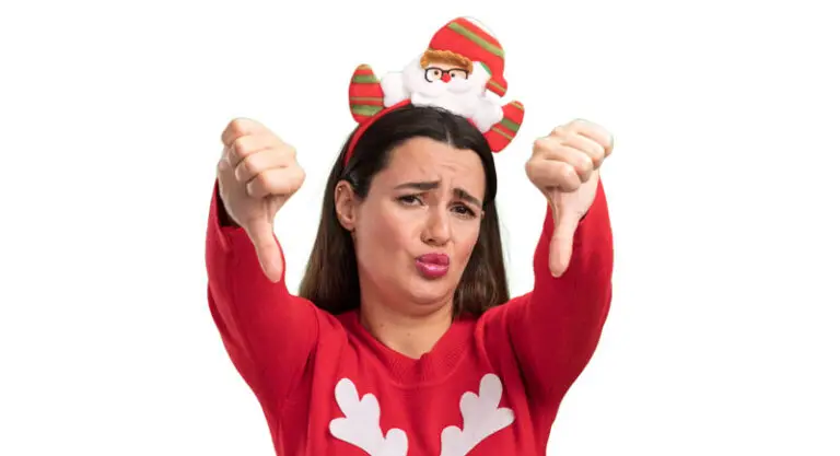 Woman in holiday outfit with thumbs pointing down