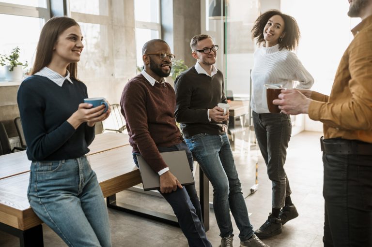 Group of employees standing around having coffee and celebrating the new Year