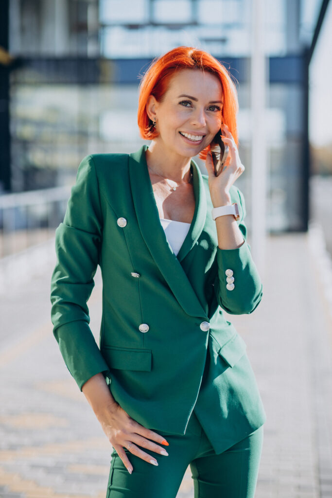HR Professional in a green suit using phone outside the street