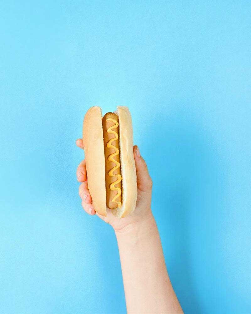 holding up a hot dog on hot dog day
